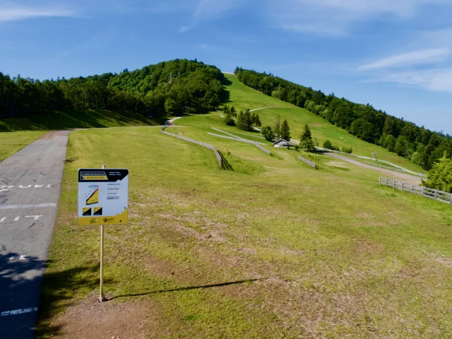 Vue sur la montée de la Planche des Belles Filles avec le panneau des arrivées officielles du Tour de France