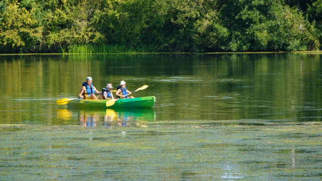 Une famille (un père et ses deux enfants) pagaye en canoë sur la rivière Ognon sous un beau soleil - Vallée de l'Ognon