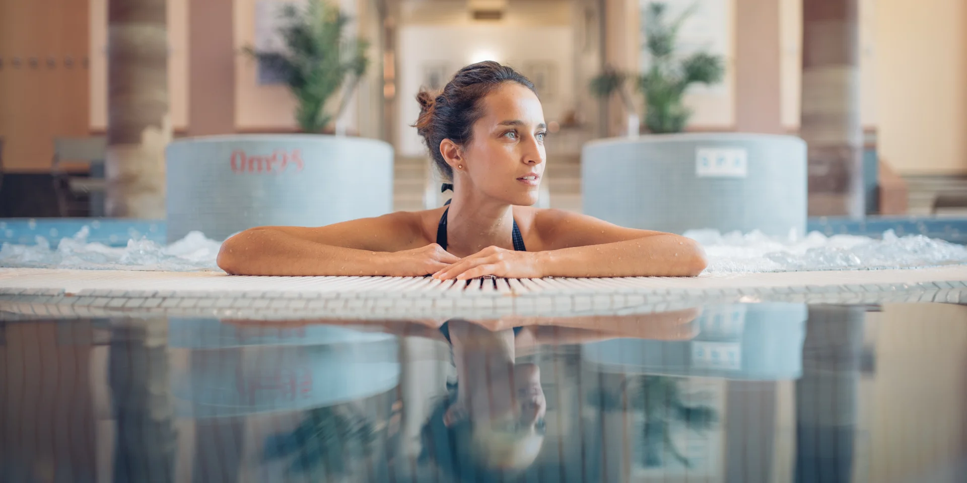 Une femme profite d'un moment bien-être et détente dans le jacuzzi des thermes de Luxeuil-les-Bains - Vosges du Sud