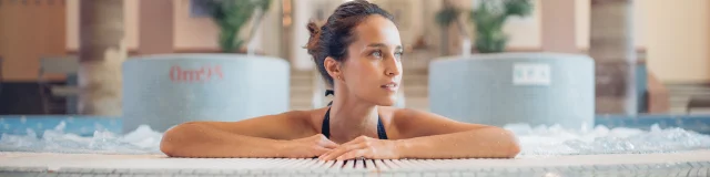 Une femme profite d'un moment bien-être et détente dans le jacuzzi des thermes de Luxeuil-les-Bains - Vosges du Sud