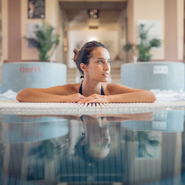 Une femme profite d'un moment bien-être et détente dans le jacuzzi des thermes de Luxeuil-les-Bains - Vosges du Sud