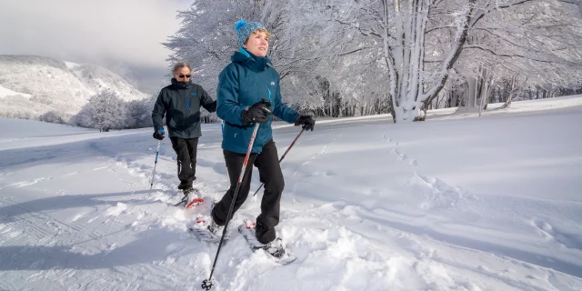 Un couple randonne avec les raquettes sous la neige au Ballon d'Alsace - Vosges du Sud