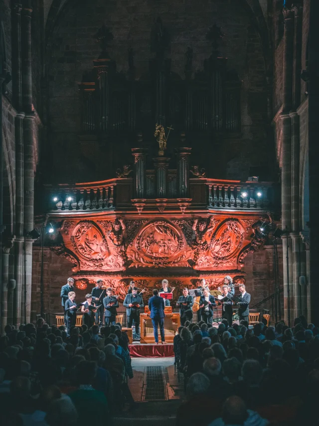 Chorale au pied de l'orgue majestueux de Luxeuil-les-Bains avec une lumière tamisée - Vosges du Sud