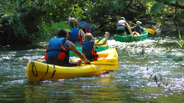 Une famille descend l'Ognon à bord d'un canoë-kayak. Ils sont équipés de gilets de sauvetage - Vallée de l'Ognon