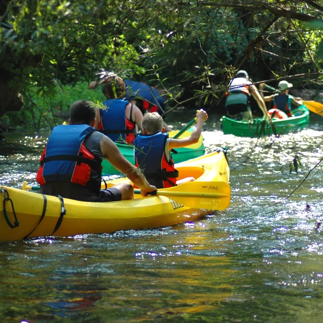 Une famille descend l'Ognon à bord d'un canoë-kayak. Ils sont équipés de gilets de sauvetage - Vallée de l'Ognon