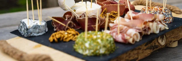 Un homme déguste un plateau de fromages de chèvres et charcuterie produit par la chèvrerie des bois pâturés de Servance - Vosges du Sud