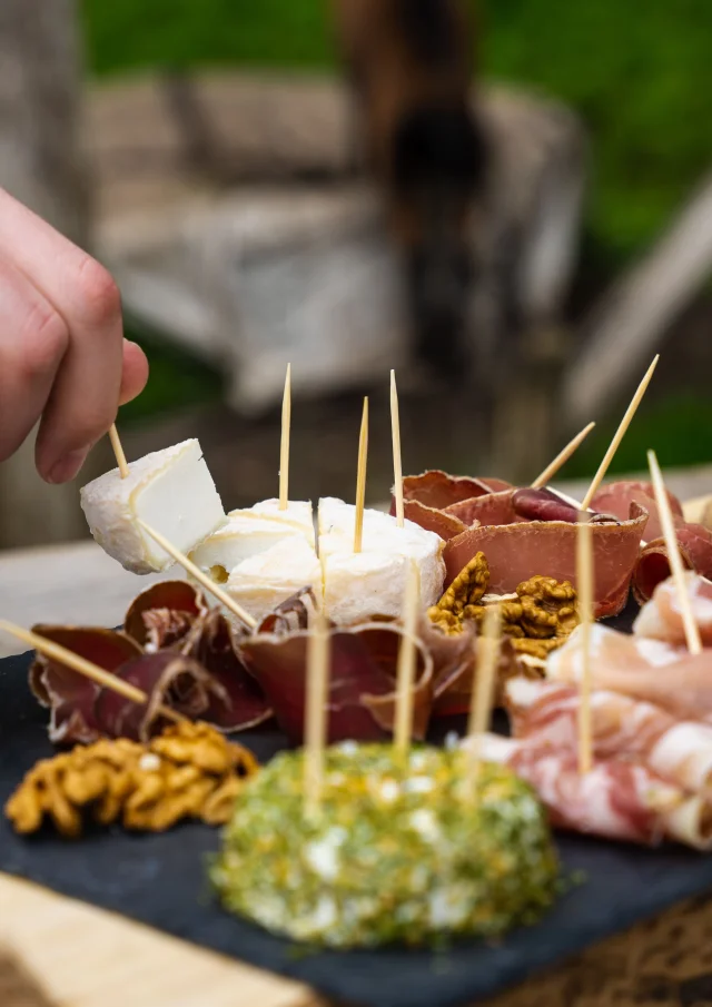 Un homme déguste un plateau de fromages de chèvres et charcuterie produit par la chèvrerie des bois pâturés de Servance - Vosges du Sud