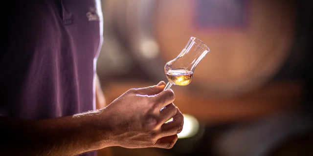 Un homme tient un verre de dégustation de Kirsch de Fougerolles - Fougerolles - Vosges du Sud