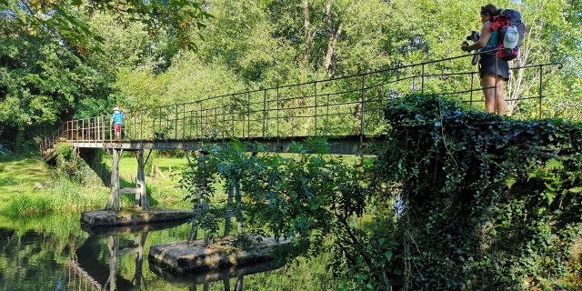 Des pèlerins traversent un pont sur la Via Francigena.