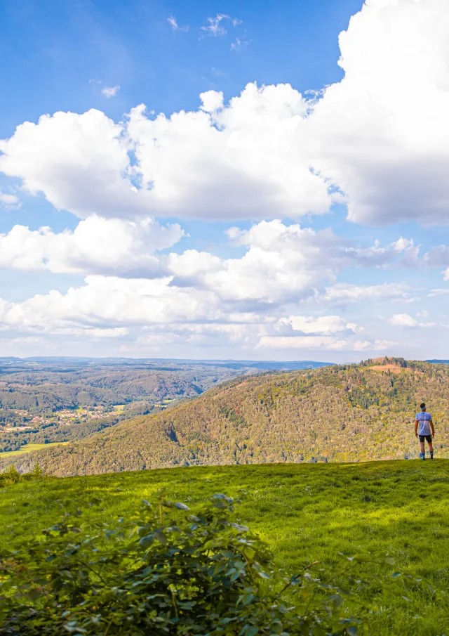 Un homme fait du Trail au Mont de Vannes, au cœur du Plateau des 1 000 étang , en forêt - Vue sur toute la vallée - Vosges du Sud