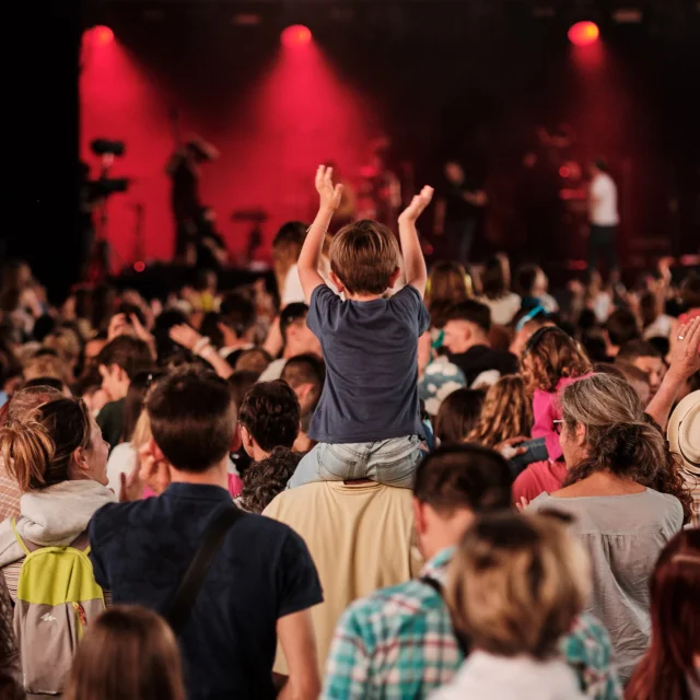 Public de festivaliers face à la scène du Rolling Saône à Gray dont un enfant qui lève les mains assis sur les épaules d'un adulte - Vesoul - Val de Saône