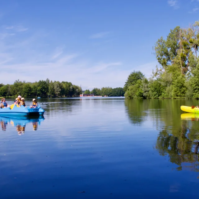 Une famille fait du pédalo sur les plans d'eau de la Base de Loisirs de la Saline à Lure. Un père et son enfant dont du kayak sur le plan d'eau - Vosges du Sud