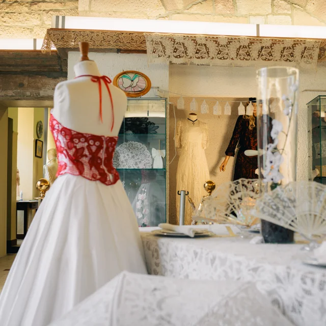 Intérieur du conservatoire de la Dentelle de Luxeuil-les-Bains. On y voit une belle robe avec le haut en dentelle rouge de Luxeuil-les-Bains - Vosges du Sud