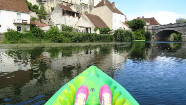 Une personne en canoë pagaie sur la rivière Ognon, au pied de la cité de Pesmes - Vallée de l'Ognon, Haute-Saône