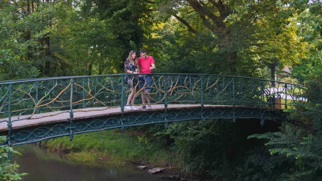 Un couple entre dans le jardin anglais de Vesoul grâce à un magnifique pont qui surplombe le Durgeon - Vesoul - Val de Saône