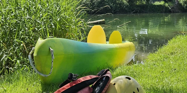 Pause au bord de la rivière avec vue sur le canoë et ses équipements (gilet, casque) - Vallée de l'Ognon