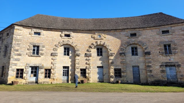 Une femme observe le bâtiment principal des Forges de Baignes - Vesoul - Val de Saône