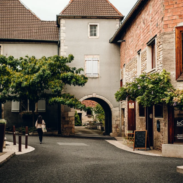 Une femme déambule dans les rues de Marnay, à sa droite se trouve le magasin de thé et café laGrange - Vincent Ballot - Barbara Bessot Ballot - Cité de Caractère - Vallée de l'Ognon