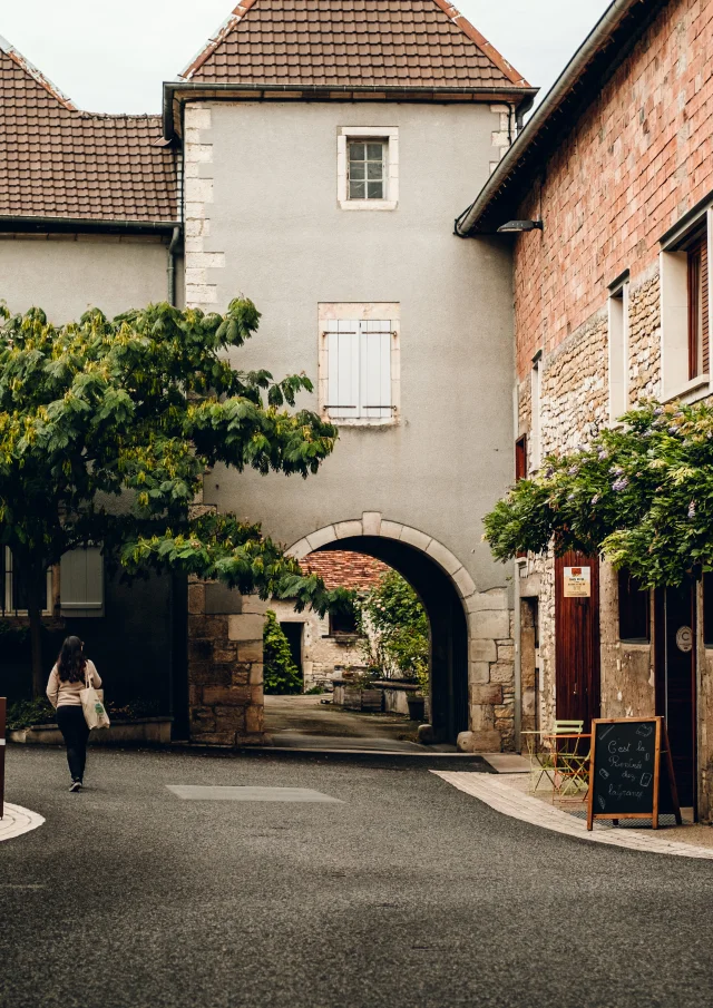 Une femme déambule dans les rues de Marnay, à sa droite se trouve le magasin de thé et café laGrange - Vincent Ballot - Barbara Bessot Ballot - Cité de Caractère - Vallée de l'Ognon