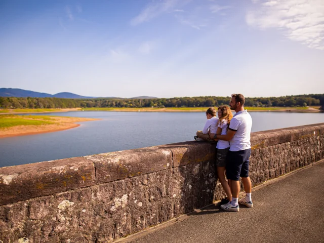 Une famille observe le bassin de Champagney . En arrière-plan, on voit le début du Massif des Vosges - Vosges du Sud