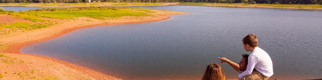 Une famille observe le bassin de Champagney . En arrière-plan, on voit le début du Massif des Vosges - Vosges du Sud