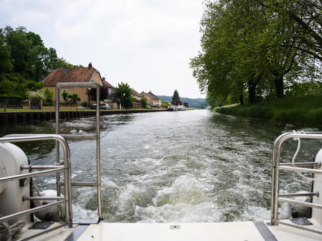 Vue depuis la poupe d'un bateau naviguant sur la Saône , à Port-sur-Saône - Vesoul - Val de Saône