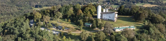 Vue aérienne de la Colline Notre-Dame du Haut, où l'on peut voir La Chapelle Le Corbusier, l'abri du pèlerin, la maison du chapelain. La Porterie et le monastère Sainte-Claire de Renzo Piano sont également visibles - Vosges du Sud