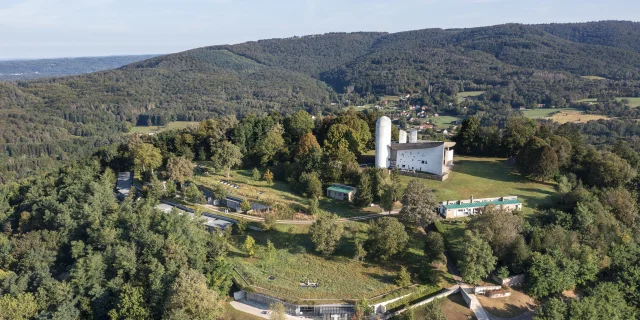 Vue aérienne de la Colline Notre-Dame du Haut, où l'on peut voir La Chapelle Le Corbusier, l'abri du pèlerin, la maison du chapelain. La Porterie et le monastère Sainte-Claire de Renzo Piano sont également visibles - Vosges du Sud