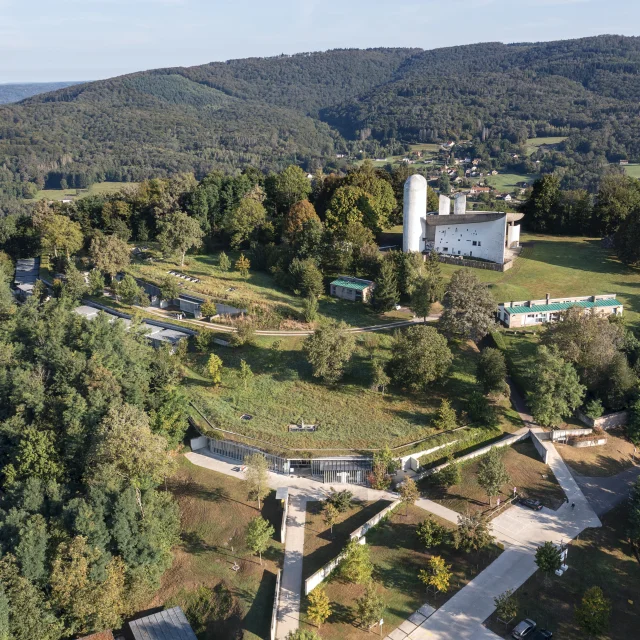 Vue aérienne de la Colline Notre-Dame du Haut, où l'on peut voir La Chapelle Le Corbusier, l'abri du pèlerin, la maison du chapelain. La Porterie et le monastère Sainte-Claire de Renzo Piano sont également visibles - Vosges du Sud