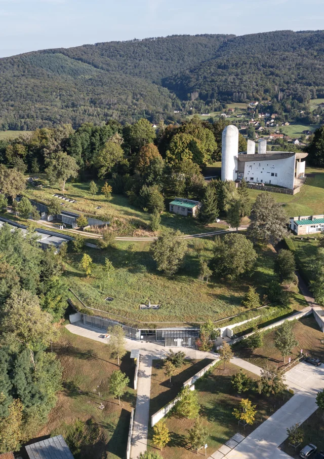 Vue aérienne de la Colline Notre-Dame du Haut, où l'on peut voir La Chapelle Le Corbusier, l'abri du pèlerin, la maison du chapelain. La Porterie et le monastère Sainte-Claire de Renzo Piano sont également visibles - Vosges du Sud