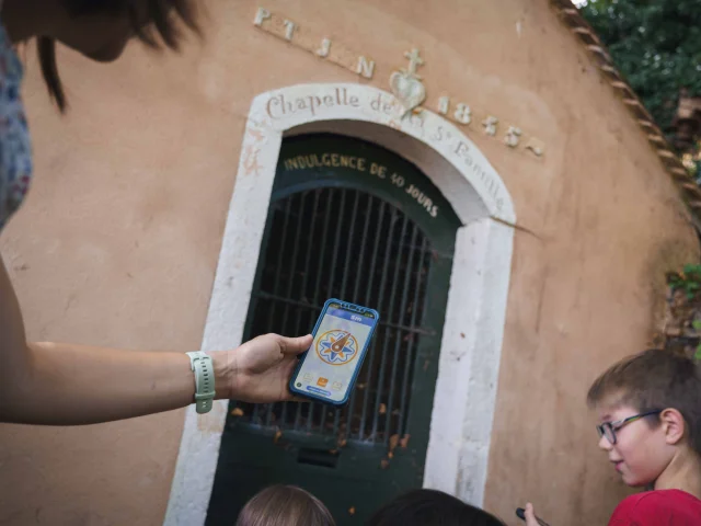 Une famille visite Jussey, grâce à l'application Baludik - à l'arrière plan, on trouve la Chapelle de la Sainte Famille - Vesoul - Val de Saône