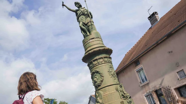 Une famille visite Jussey, grâce à l'application Baludik - On aperçoit une fontaine avec une statue de femme - Vesoul - Val de Saône