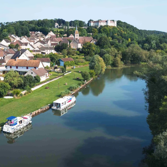 Vue aérienne de Ray-sur-Saône où on voit le château sur son éperon rocheux - La Saône est au premier plan, 2 bateaux sont accostés - Vesoul - Val de Saône