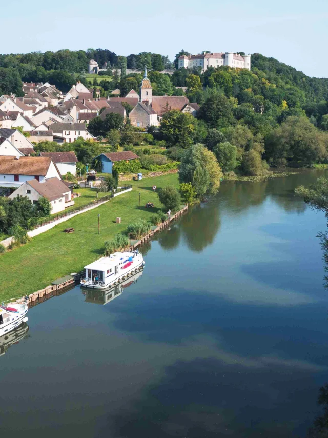 Vue aérienne de Ray-sur-Saône où on voit le château sur son éperon rocheux - La Saône est au premier plan, 2 bateaux sont accostés - Vesoul - Val de Saône