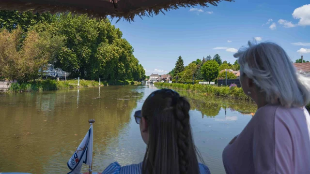 Deux femmes sont sur la proue d'un bateau et naviguent sur la Saône - Vesoul - Val de Saône