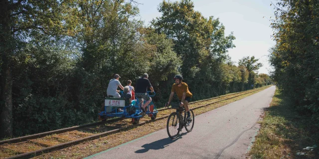 Un cycliste emprunte la Trace du Courlis qui permet de faire la liaison entre la V50 et l'EV6 - A ses côtes, on retrouve une famille qui fait du vélorail - Vesoul - Val de Saône