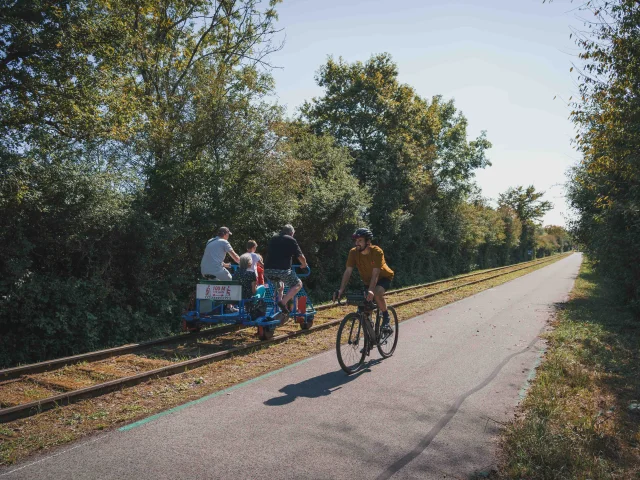 Un cycliste emprunte la Trace du Courlis qui permet de faire la liaison entre la V50 et l'EV6 - A ses côtes, on retrouve une famille qui fait du vélorail - Vesoul - Val de Saône