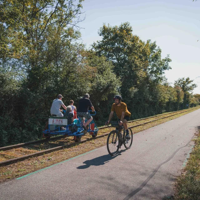 Un cycliste emprunte la Trace du Courlis qui permet de faire la liaison entre la V50 et l'EV6 - A ses côtes, on retrouve une famille qui fait du vélorail - Vesoul - Val de Saône