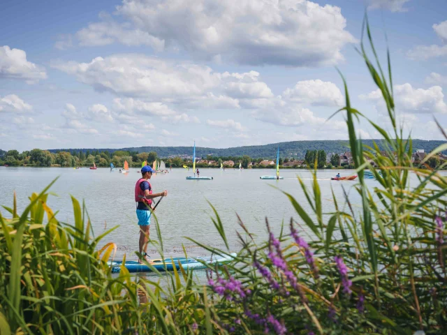 Une personne fait du paddle sur le lac de Vesoul-Vaivre en fond, on voit des personnes qui font de la planche à voile - Vesoul - Val de Saône