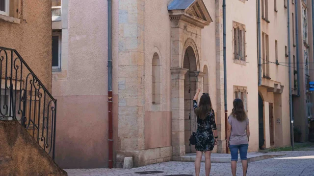 Deux femmes se promènent dans les rues pavées de Vesoul. Il y observe un bâtiment religieux en pierre - Vesoul - Val de Saône