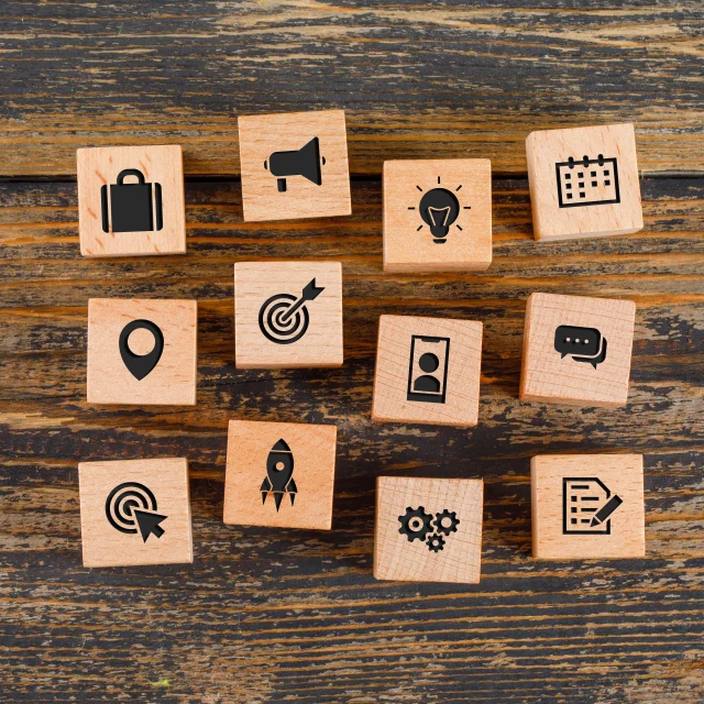 Business concept with icons on wooden cubes on wooden background flat lay.