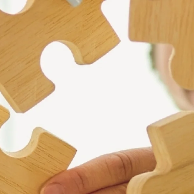 Un groupe de personnes assemblent les pièces d'un puzzle en bois - Accompagnement de projets touristiques par Destination 70