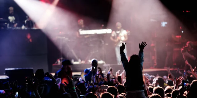 Public de festivaliers face à la scène du Rolling Saône à Gray dont un enfant qui lève les mains assis sur les épaules d'un adulte - Vesoul - Val de Saône