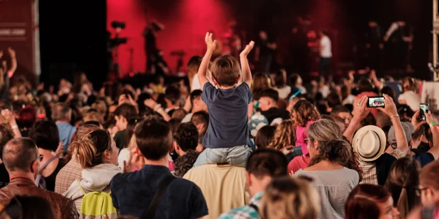 Public de festivaliers face à la scène du Rolling Saône à Gray dont un enfant qui lève les mains assis sur les épaules d'un adulte - Vesoul - Val de Saône