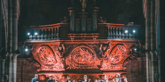 Chorale au pied de l'orgue majestueux de Luxeuil-les-Bains avec une lumière tamisée - Vosges du Sud