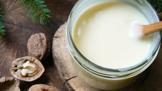 Un pot de cancoillotte avec une cuillère en bois prêt à être déguster