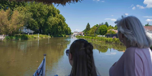 Deux femmes sont sur la proue d'un bateau et naviguent sur la Saône - Vesoul - Val de Saône