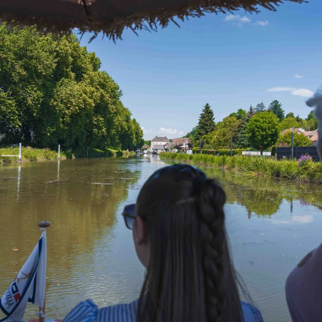 Deux femmes sont sur la proue d'un bateau et naviguent sur la Saône - Vesoul - Val de Saône