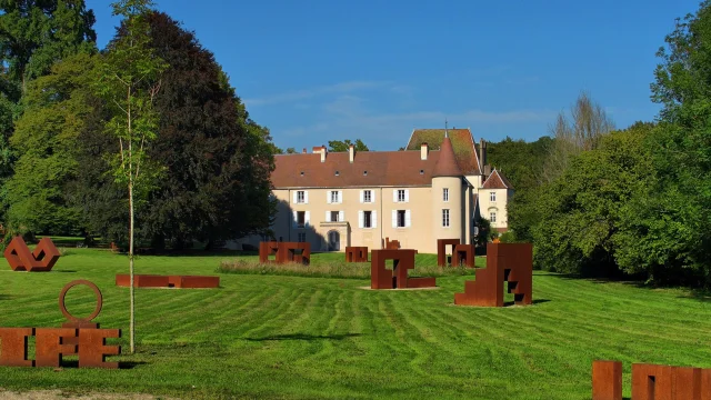 Vue sur des sculptures et le château du parc Ile Art à Malans - Vallée de l'Ognon, Haute-Saône