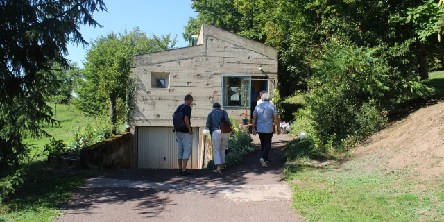 Des personnes qui visitent la Colline Notre-Dame du Haut entre dans la Maison du Chapelain réalisé par Le Corbusier - Vosges du Sud